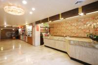 a restaurant with a bar in a lobby with floral wallpaper at Chiayi Crown Hotel in Chiayi City