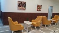 a waiting room with yellow chairs and tables at Ideal city in Tutin