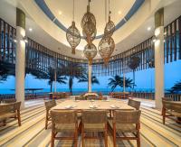 Un comedor con mesa y sillas y el océano. en Ban Saithong Beach Resort, en Bang Saphan Noi