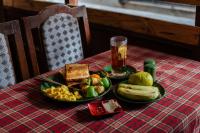 einen Teller mit Lebensmitteln auf einem Tisch mit einem Obstteller in der Unterkunft Hotel Pomelo House in Kathmandu