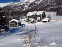 una casa está cubierta de nieve con una montaña en Apartment between Ustaoset and Geilo, en Geilo