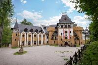 a large brick building with a black roof at Zámek Lužec Spa &amp; Wellness Resort in Karlovy Vary
