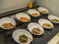 a group of bowls of food on a counter at Watermark Hotel - Sizihwan in Kaohsiung