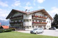 un gran edificio blanco con flores en un aparcamiento en Pension Sonnenheim, en Schönberg im Stubaital