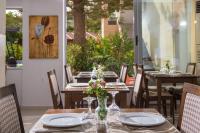 ein Tisch mit einer Vase mit Blumen darauf in der Unterkunft South Coast Hotel in Makry Gialos