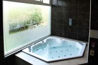 a bath tub in a bathroom with a window at Guanziling Lin Kuei Yuan Hot Spring Resort in Baihe