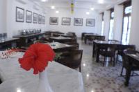 Un comedor con una flor roja en un jarrón. en Daroessalam Syariah Heritage Hotel, en Pasuruan