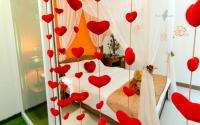 a room with red hearts hanging from a bed at sweet home B&amp;B in Hualien City