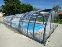 a glass greenhouse with a swimming pool in it at Le Chêne Liège in Maché