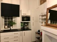 a kitchen with white cabinets and a black counter top at Magnifiques Appartements Hyper Centre in Nantes