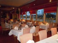 モントリシャールにあるHôtel Restaurant Le Bellevue Montrichard 3 étoilesの白いテーブルと椅子と窓のあるレストラン