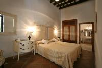 a bedroom with a bed and a table and a mirror at Posada de Palacio in Sanlúcar de Barrameda