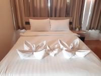 a white bed with three white flowers on it at Nice Sea Resort in Srithanu