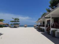 a beach with umbrellas and the ocean in the background at Nice Sea Resort in Srithanu