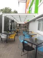 un patio esterno con tavoli, sedie e tende da sole di Zuri Express Jimbaran a Jimbaran