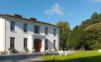 una casa blanca con sillas blancas delante en Springfort Hall Hotel, en Mallow