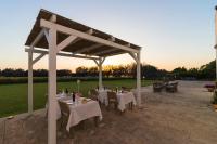 un padiglione con tavoli e sedie bianchi e il tramonto di Casina Bardoscia a Cutrofiano