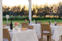 un set di tavoli con tovaglie bianche e bottiglie di vino di Casina Bardoscia a Cutrofiano