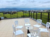 a patio with white chairs and a table with a view at I Leisure B&amp;B in Yuanshan