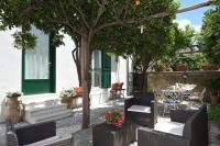 a patio with chairs and tables and a tree at Nicola e Magda in Ravello