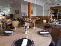 Un comedor con mesas y sillas con platos y vasos. en Come Inn, en Neufchâtel-en-Bray