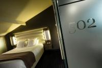 a hotel room with a bed and a sliding glass door at Hôtel de Brienne in Toulouse