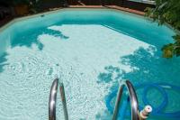 a swimming pool with blue water and metal rails at Chambres d&#39;Hôtes Villa Bellevue in Albi