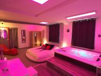 a bedroom with two beds and pink lighting at Suite Cupidon- Domaine des trois châteaux in Moisenay
