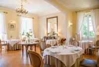 Un restaurante con mesas y sillas y una lámpara de araña. en Logis Hôtel Restaurant Château Bellevue, en Cazaubon