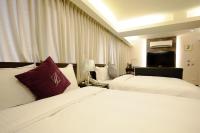 a hotel room with two beds with white sheets at 意芙旅店 Ifinn Hotel in Taipei