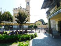 a courtyard with tables and chairs and a clock tower at Trattoria Due Citroni in Casalgrasso