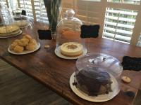 een houten tafel met taarten en koekjes op borden bij Beachbreak Holiday Letting in Durban