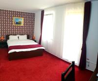 a bedroom with a bed and a red carpet at Hotel Hermes in Eforie Nord