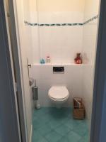 a small bathroom with a toilet and a blue tile floor at Villa Bellochio in Menton