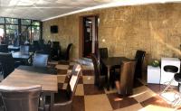 a restaurant with wooden tables and chairs and a wall at Hotel Hermes in Eforie Nord