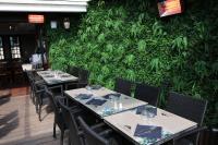 a restaurant with tables and chairs in front of a green wall at Le Mouton Blanc in Le Mont Saint Michel