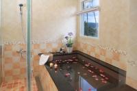 a bathroom with a bath tub with flowers on the floor at Spring Fountain Hotel in Jiaoxi