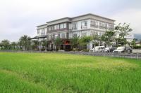 a large house with a grass field in front of it at Spring Fountain Hotel in Jiaoxi