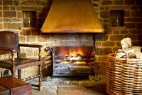 The Marquess of Exeter في ابنجهام: مدفأة في غرفة بها كرسي وكرسي