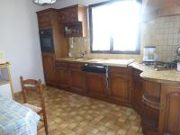 a kitchen with wooden cabinets and a sink and a window at les volets bleus in Camaret-sur-Mer