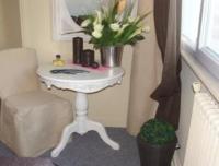 a table with a vase of flowers and a mirror at Hôtel De Londres in Boulogne-sur-Mer