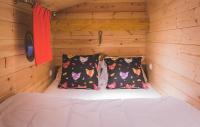 a bed in a wooden cabin with two pillows at L&#39;Escale des Châteaux de la Loire in Angé