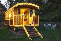 a yellow play house with a guitar in a yard at L&#39;Escale des Châteaux de la Loire in Angé