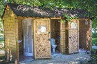 a wooden shed with three doors and a toilet at L&#39;Escale des Châteaux de la Loire in Angé