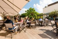 a group of people sitting at tables on a patio at Hotel Neues Tor in Bad Wimpfen