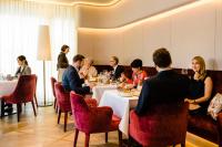 a group of people sitting around a table in a restaurant at Hotel Neues Tor in Bad Wimpfen