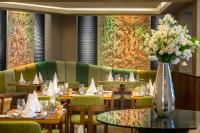 a restaurant with tables and chairs and a vase of flowers at Four Seasons Hotel in Limassol