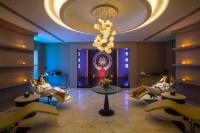 two women sitting in chairs in a lobby with a chandelier at Four Seasons Hotel in Limassol