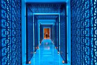 a hallway in a blue building with a person walking down it at Four Seasons Hotel in Limassol
