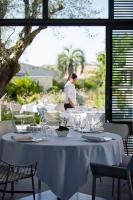 uma mesa com taças de vinho e uma pessoa ao fundo em Sezz Saint-Tropez em Saint-Tropez